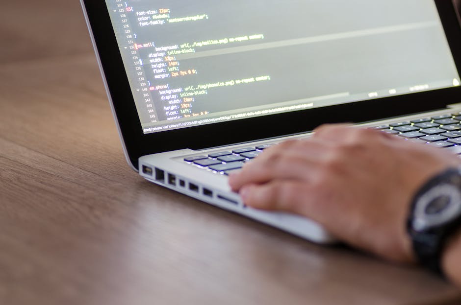 A close-up photograph of a computer screen displaying lines of HTML code in various colours, including tags, attributes, and text. The code includes references to image files such as 'bibek's photo' a